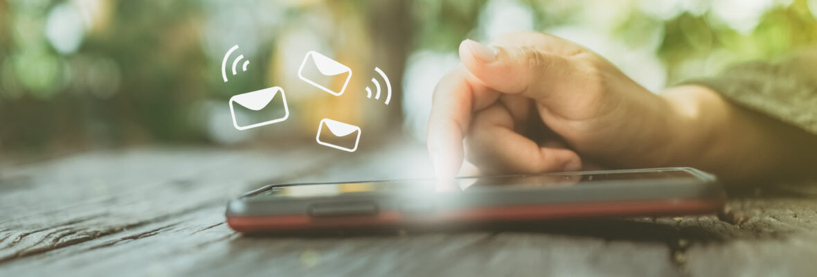 Woman hand using smartphone to send and recieve email for business on nature bokeh background.